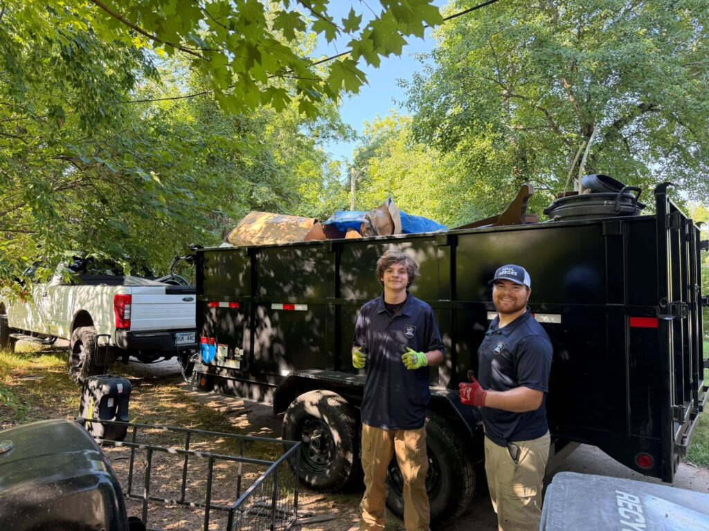 KB Haul Heroes crew loading a full 14.5 cubic yard dump trailer, Northwest Arkansas junk removal